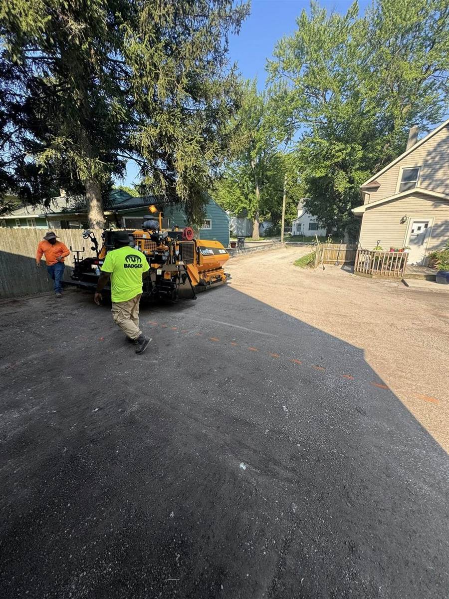 Crew running a Badger paver on a residential street