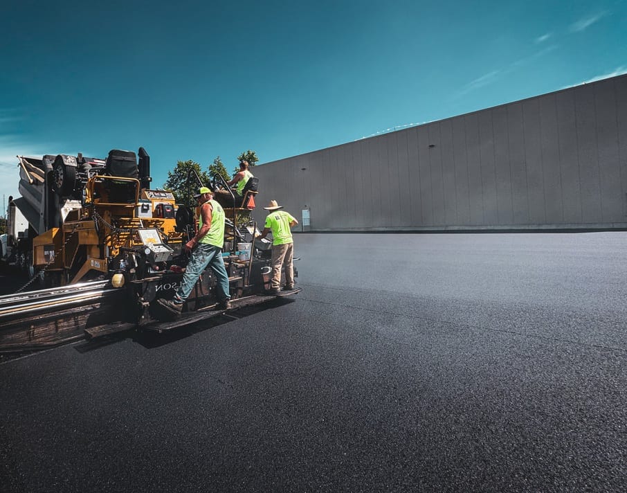 Industrial asphalt paving near a steel-frame building