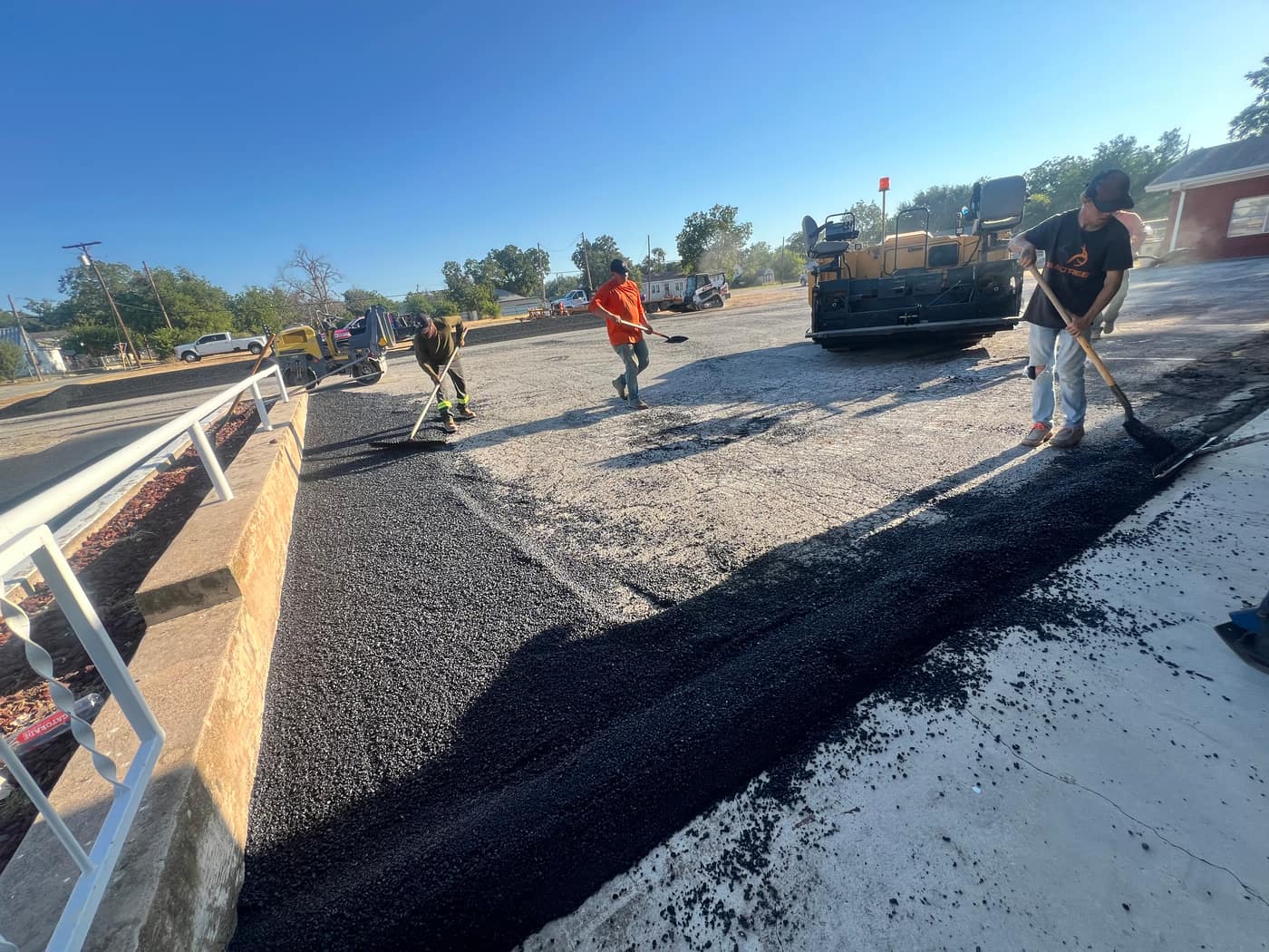 Asphalt repair crew patching a damaged parking lot