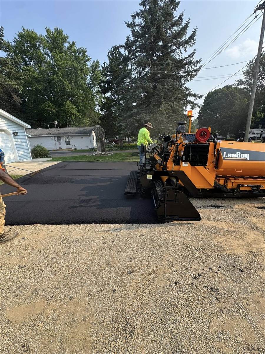 LeeBoy paver laying hot mix on a residential street