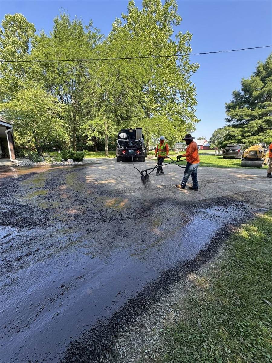 Paul's crew applying sealcoat to an asphalt driveway